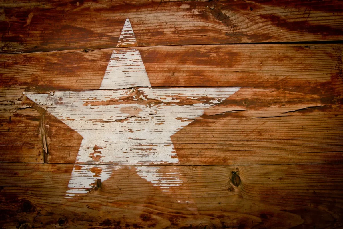 White Texas star painted on weathered wooden boards