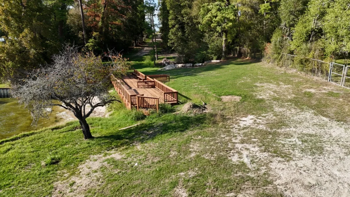 Wooden deck beside a grassy clearing and trees