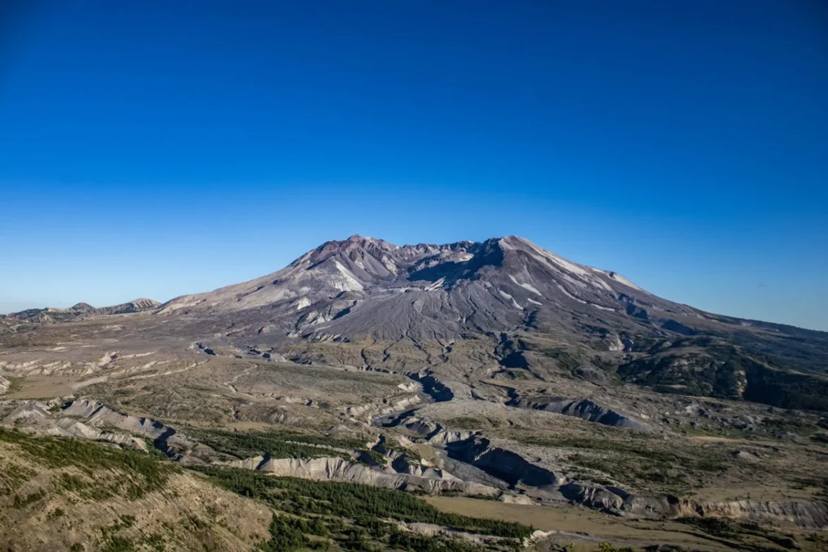 Broad volcanic mountain beneath a clear blue sky