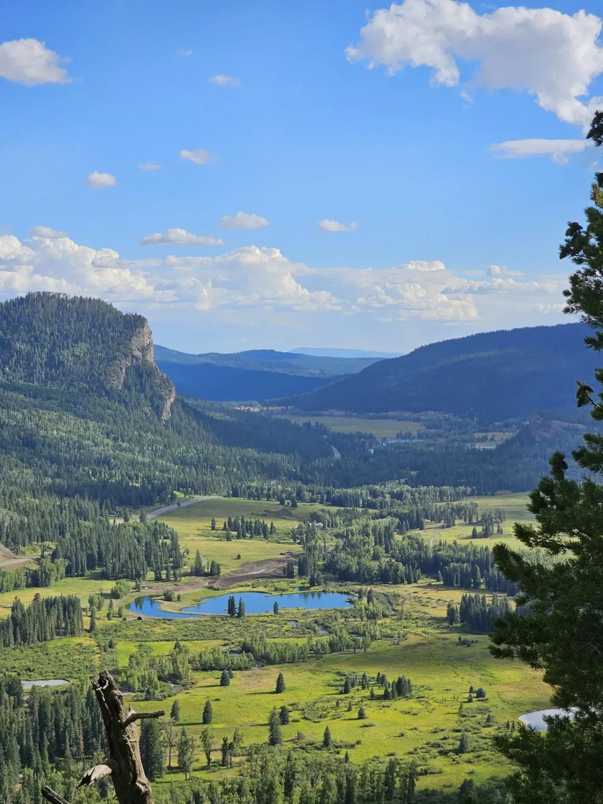 Mountain valley with fields, trees, and distant ridges
